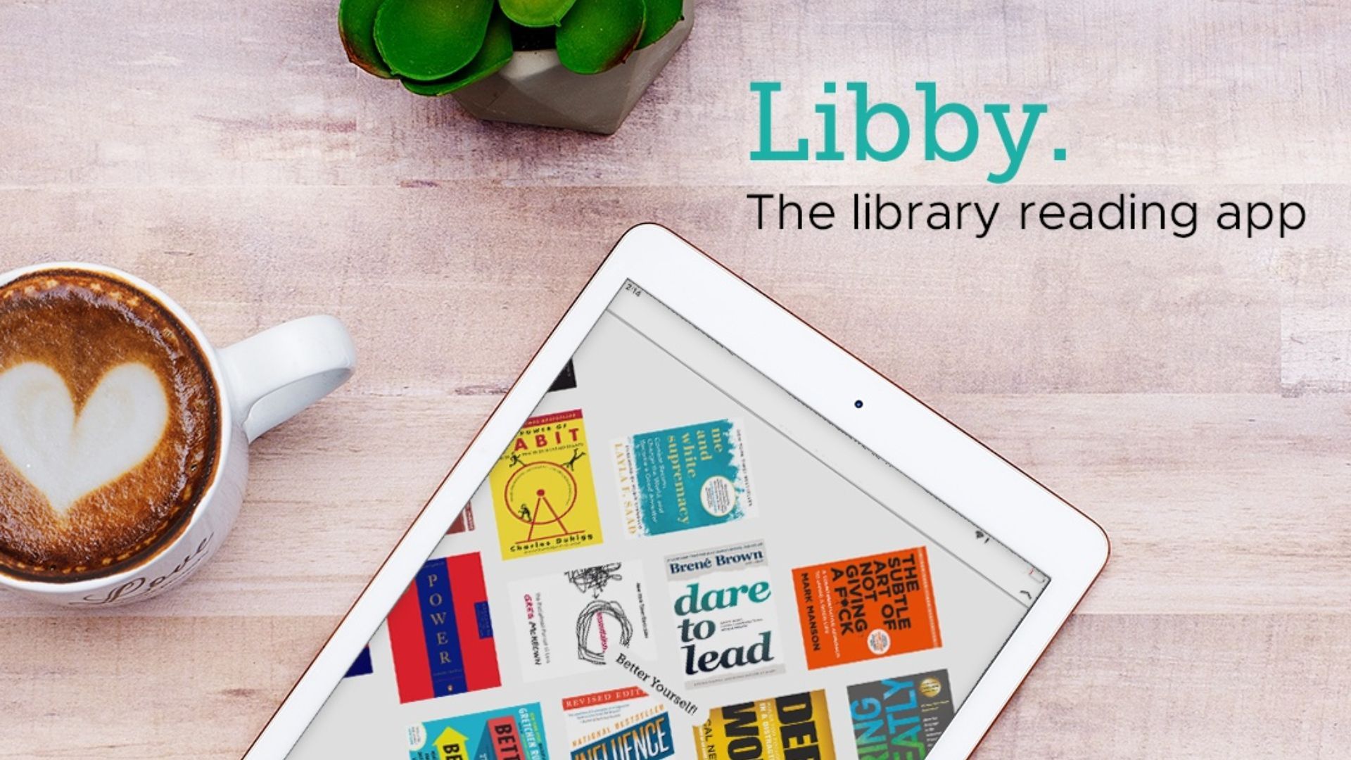 تم سحب تطبيق قراءة مكتبة libby على جهاز لوحي على طاولة خشبية 