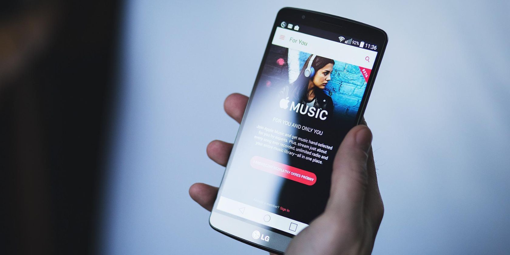 شخص يحمل هاتفًا به تطبيق Apple Music على الشاشة 