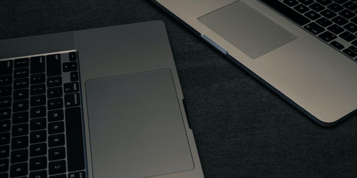 dua macbook dengan fokus pada trackpad