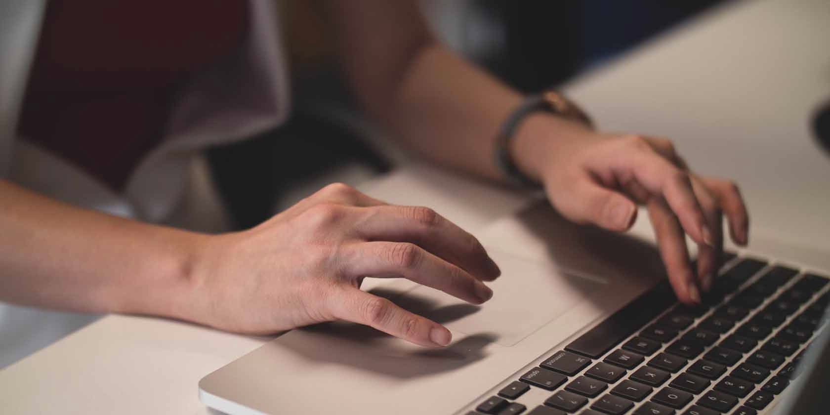 Person Using MacBook\'s Trackpad