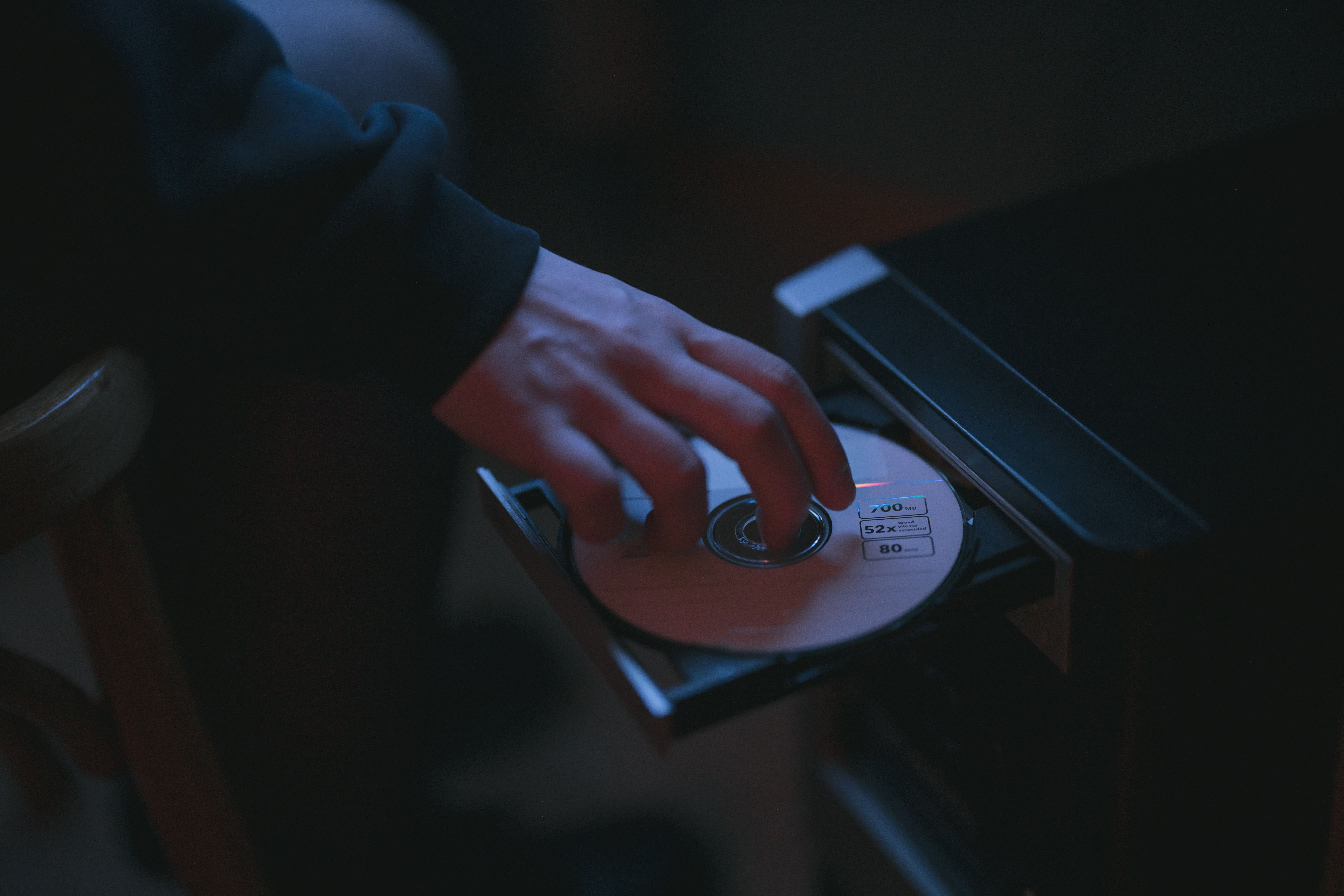 Person Loading CD Into Computer